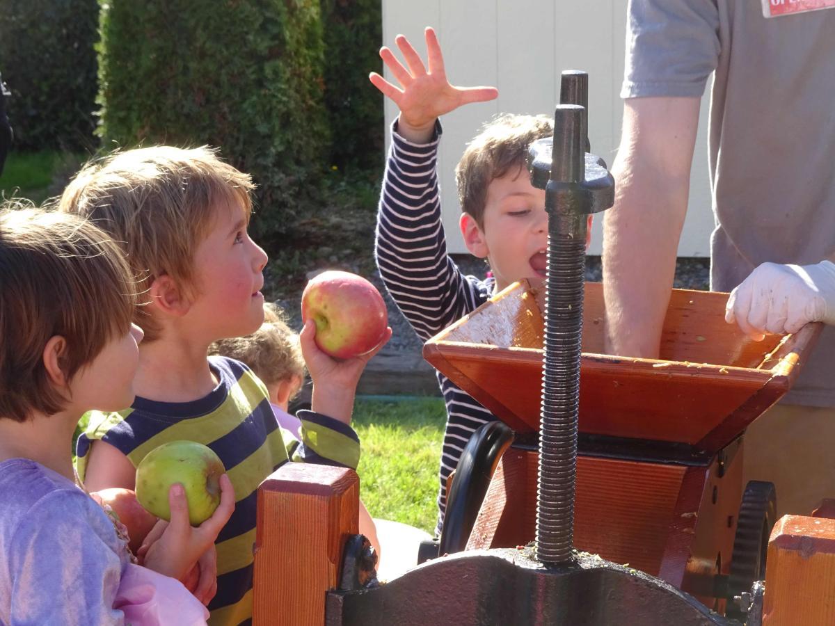 Children Enjoying the Apple Squeeze
